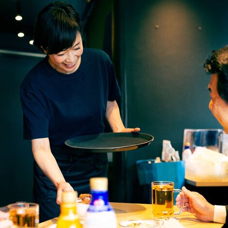 料理を運ぶ女性スタッフ