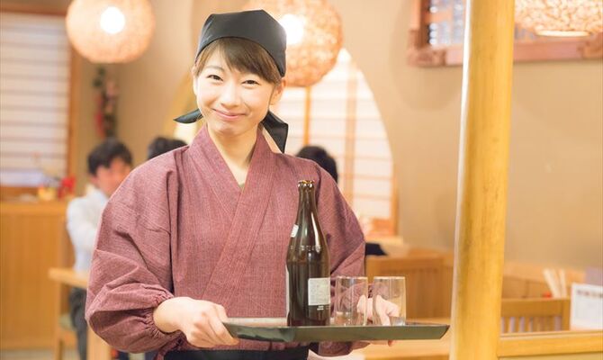 瓶ビールを運ぶ女性スタッフ